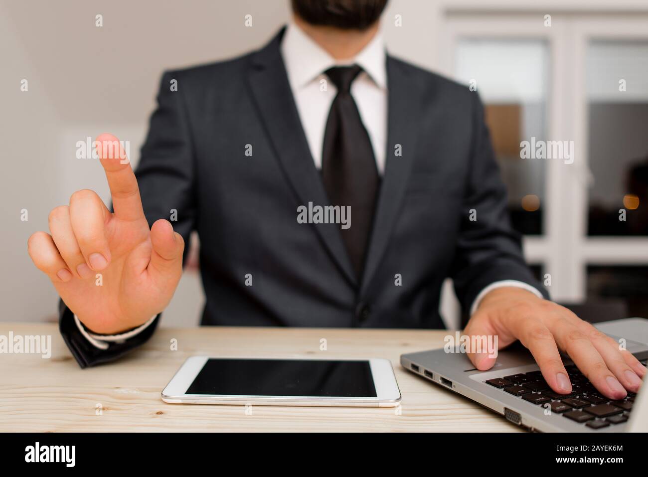 Homme vêtements de travail habillés vêtements de travail formels présentant la présentation d'un smartphone de haute technologie. Homme vêtu d'un costume de travail pl Banque D'Images
