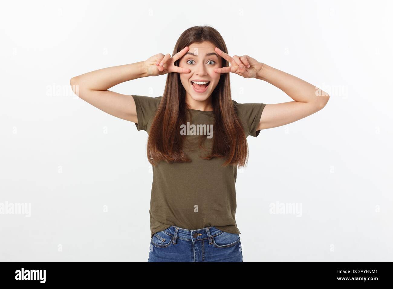 Jeune femme montrant deux doigts, positif ou geste de paix, sur fond blanc. Banque D'Images