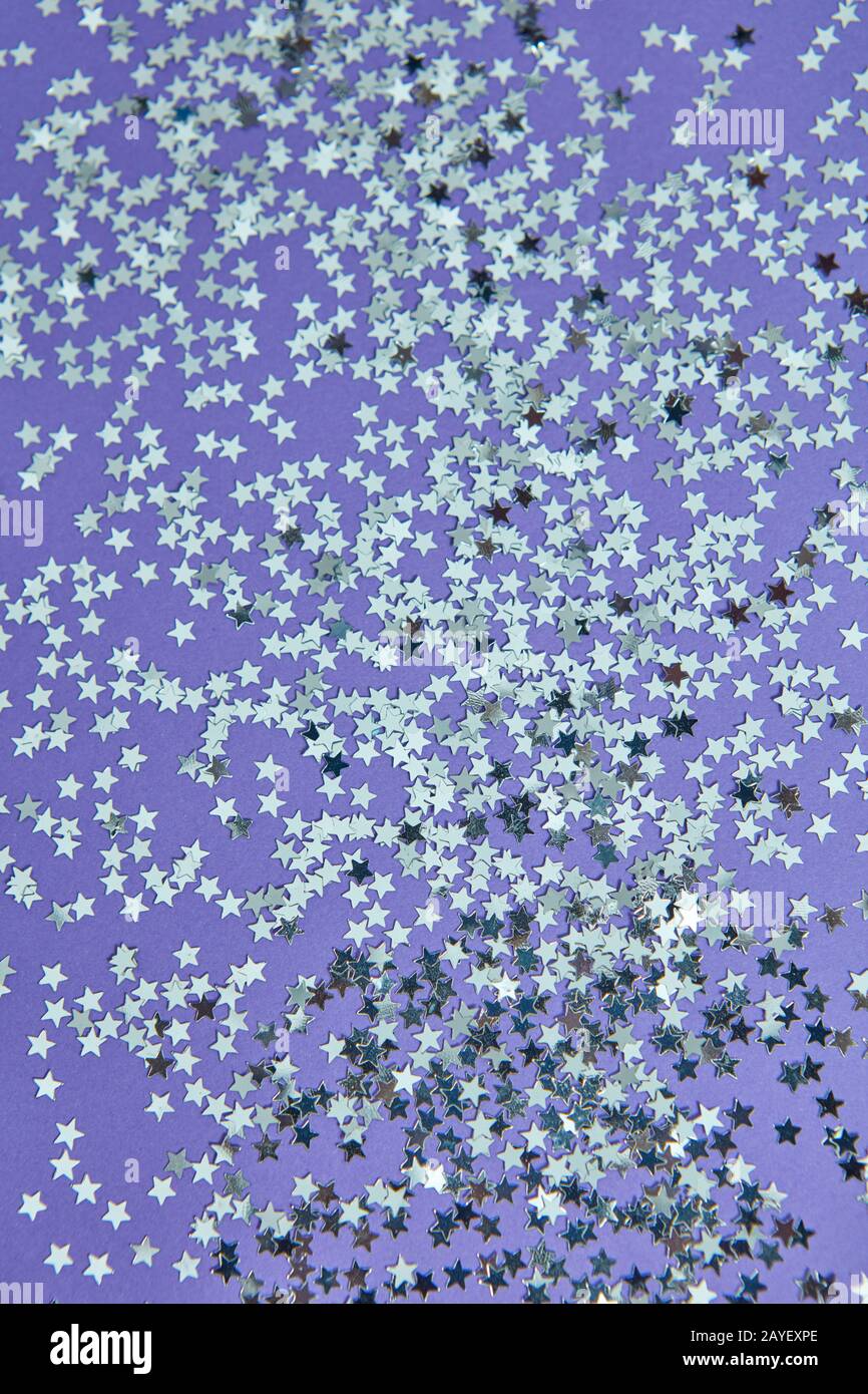 Fond de Noël à partir de petites étoiles pailletée sur un papier lilas. Banque D'Images