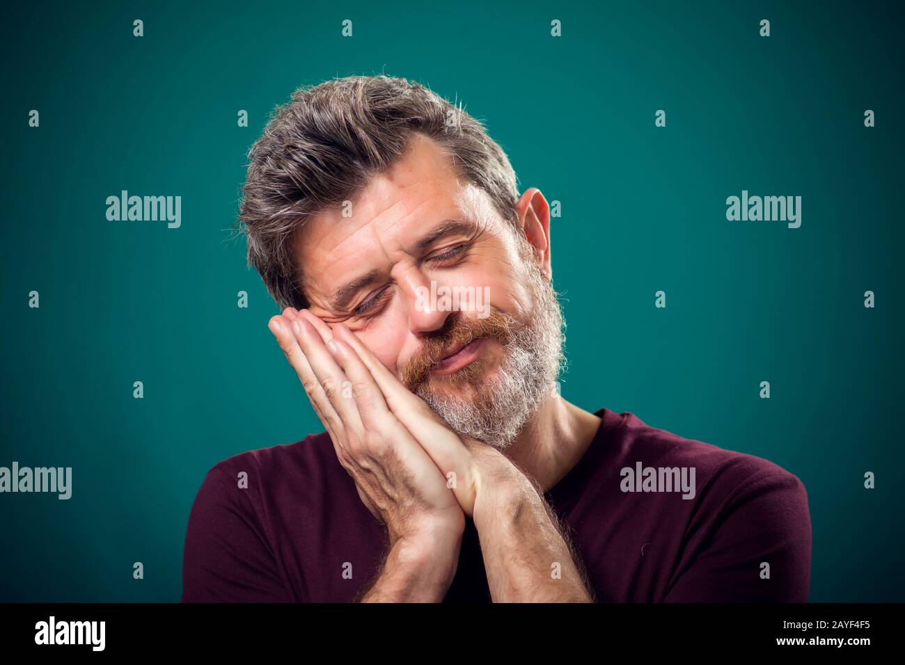 Un portrait d'homme barbu dans un t-shirt rouge avec geste de sommeil. Concept de personnes et d'émotions Banque D'Images