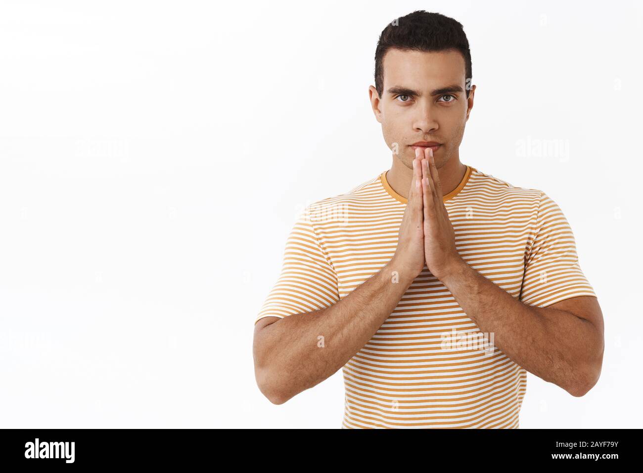 La réalisation prend patience. Athlète masculin déterministe calme, faire du namaste, des gestes d'arts martiaux, prier ou pleurer, regardant concentré et auto Banque D'Images