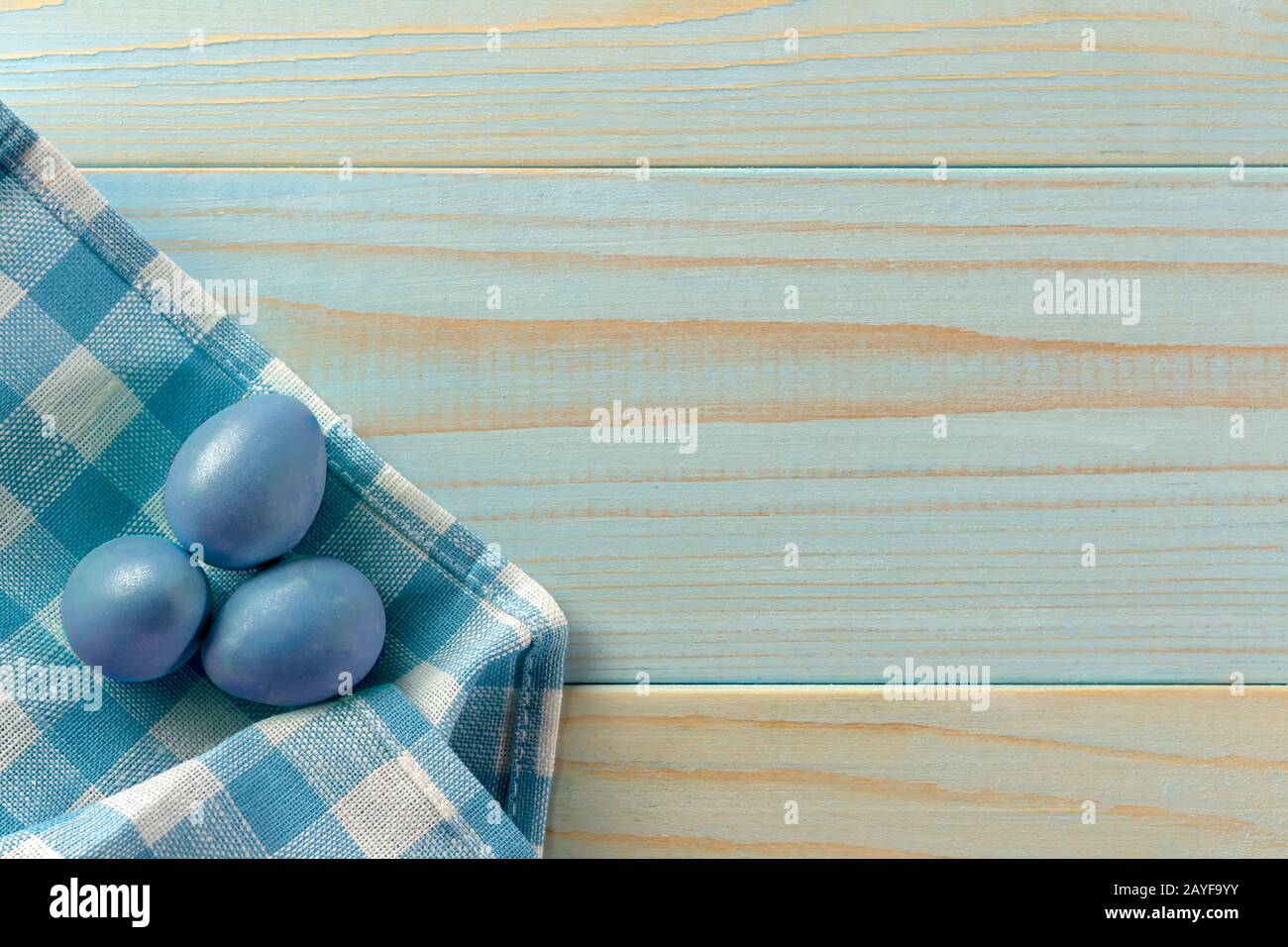 Joyeuses Pâques. Œufs de couleur sur une serviette dans une cage. Fond en bois, style rustique. Chasse aux œufs. Banque D'Images