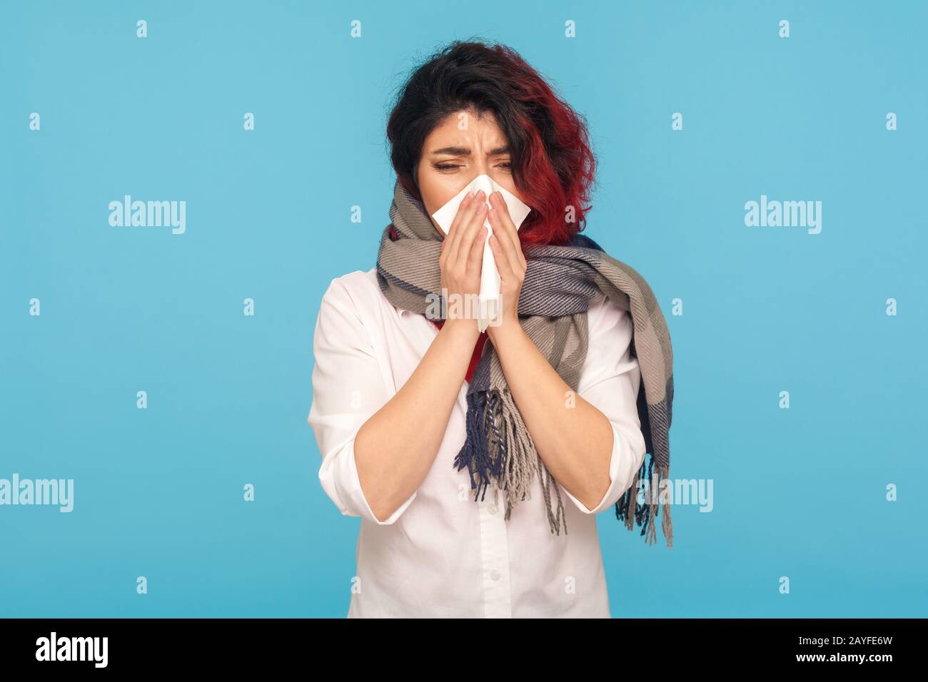 Épidémie de virus, épidémie de grippe. Femme malade enveloppée dans un foulard éternuant dans la serviette, le nettoyage du nez et de la toux, souffrant de symptômes de la grippe, de la fièvre. Banque D'Images