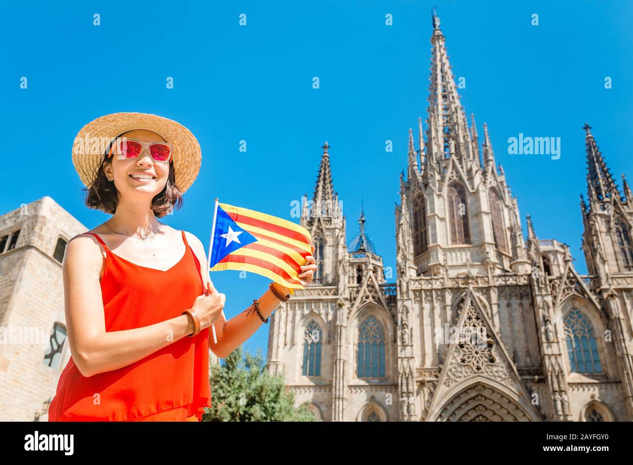 Jeune femme avec drapeau catalan devant la célèbre cathédrale d'Eulalia de Barcelone, concept Travel in Spain Banque D'Images