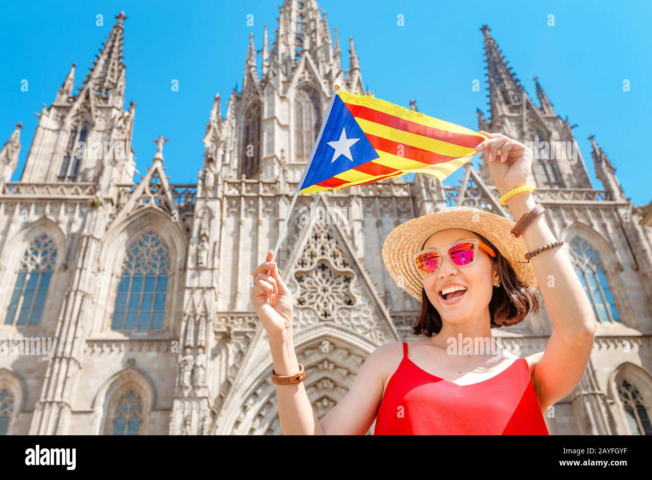 Jeune femme avec drapeau catalan devant la célèbre cathédrale d'Eulalia de Barcelone, concept Travel in Spain Banque D'Images