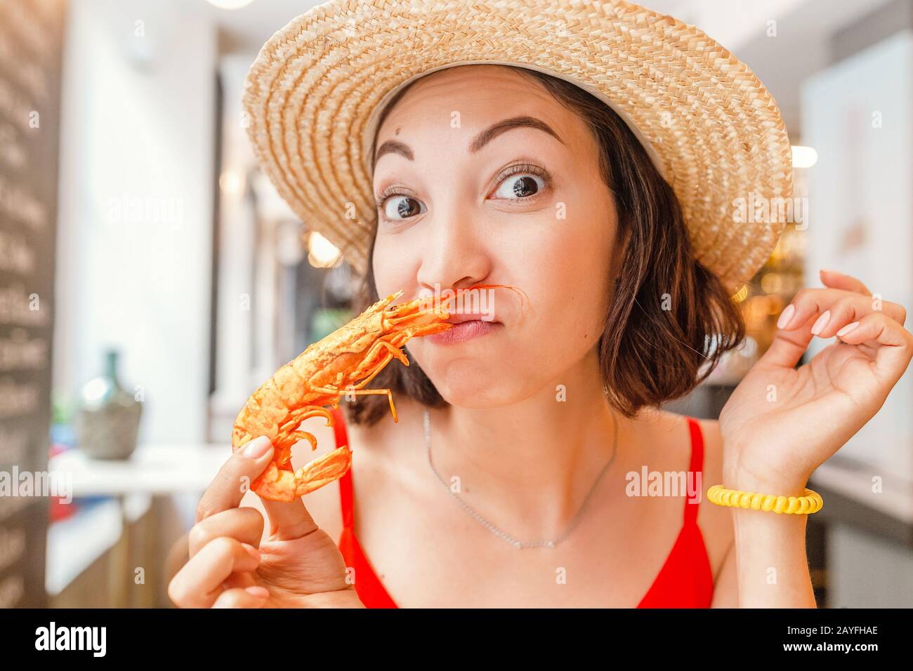 Bonne femme asiatique à chapeau manger de la cuisine locale espagnole grillades de fruits de mer Banque D'Images