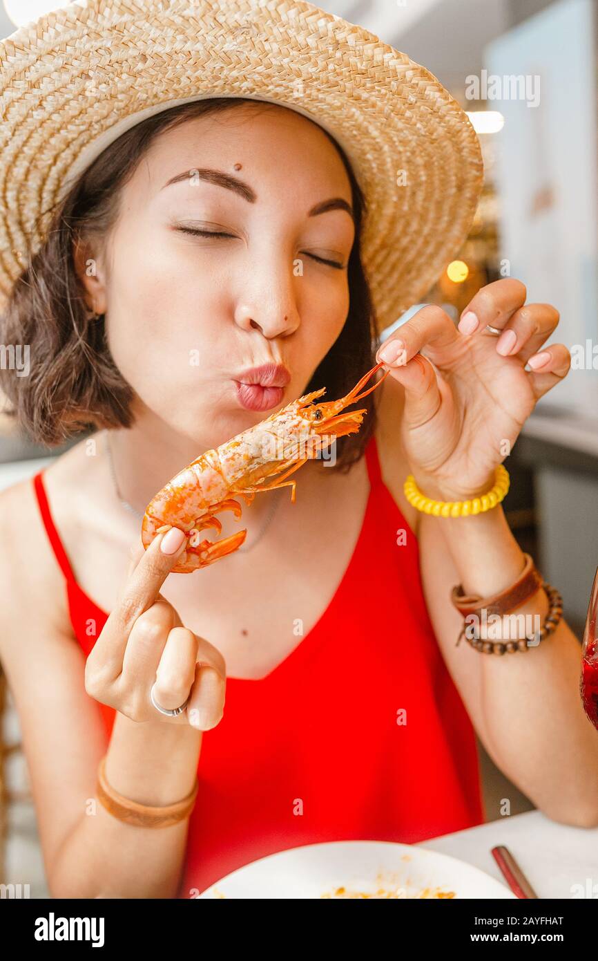 Bonne femme asiatique à chapeau manger de la cuisine locale espagnole grillades de fruits de mer Banque D'Images