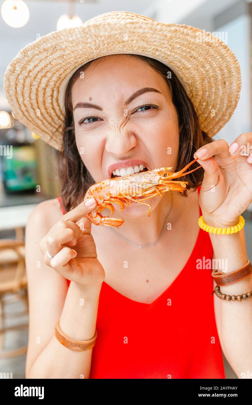 Bonne femme asiatique à chapeau manger de la cuisine locale espagnole grillades de fruits de mer Banque D'Images