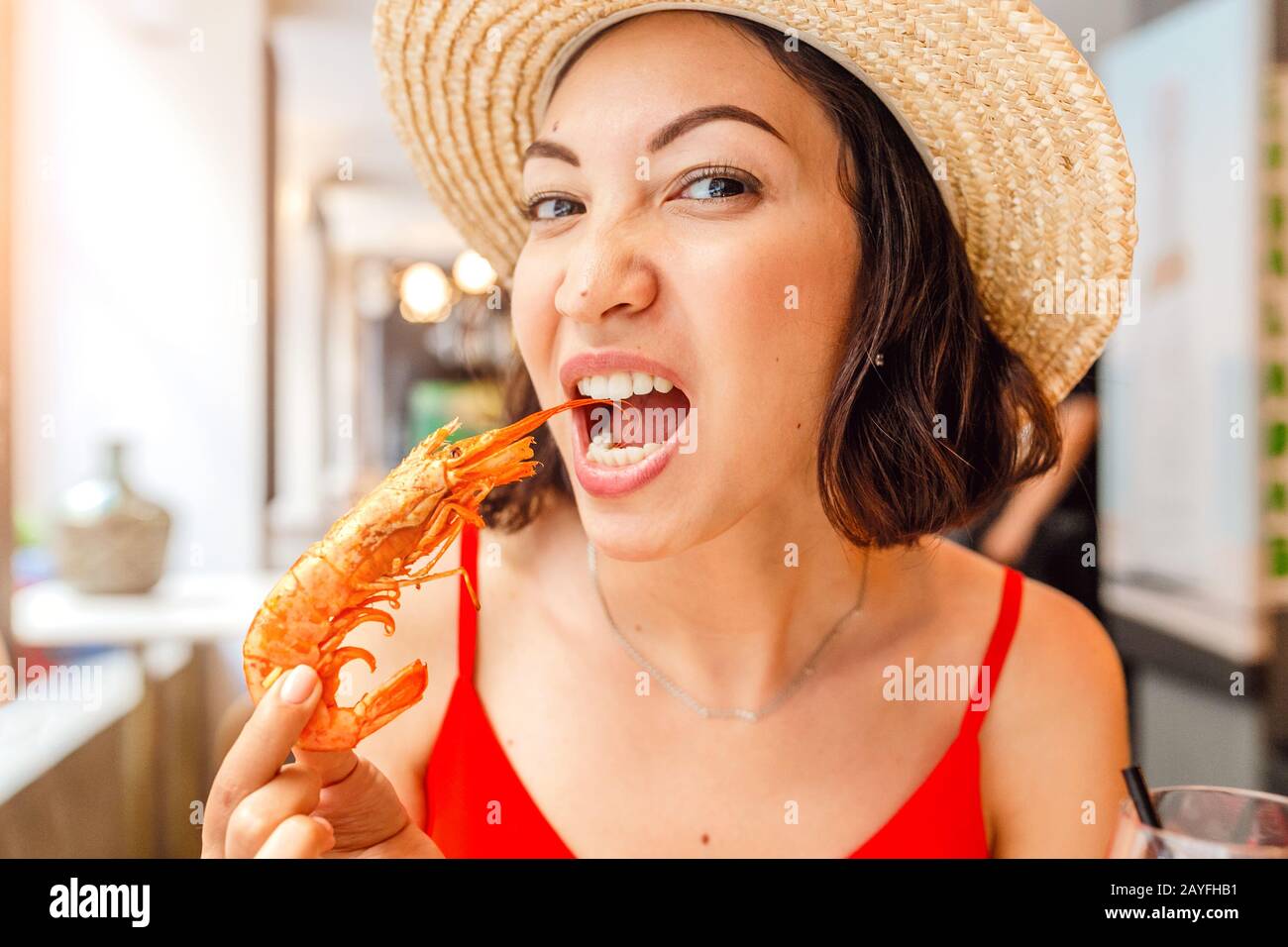 Bonne femme asiatique à chapeau manger de la cuisine locale espagnole grillades de fruits de mer Banque D'Images