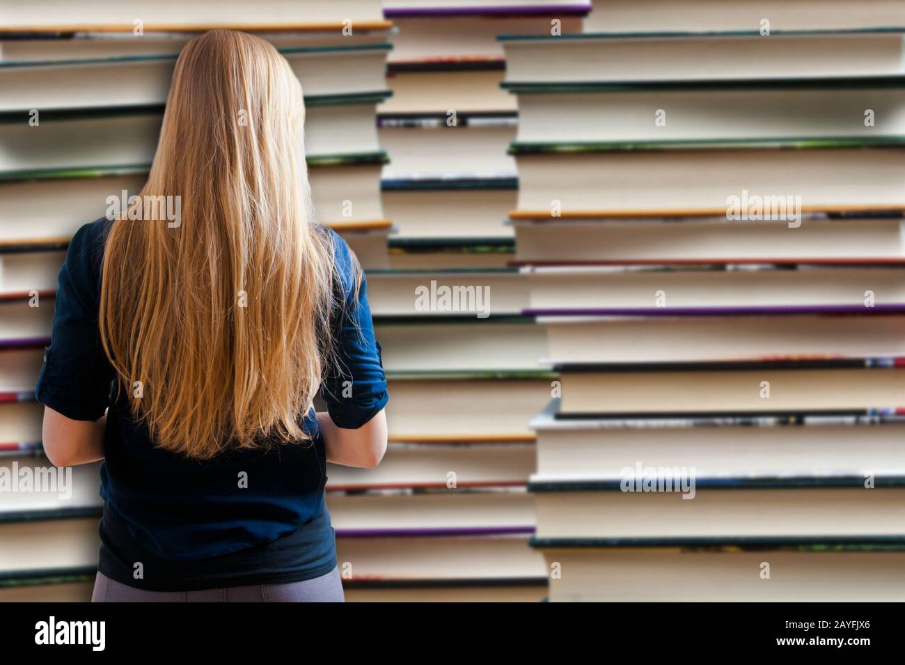 Fille debout devant des piles de livres - le concept de jour du Livre mondial Banque D'Images