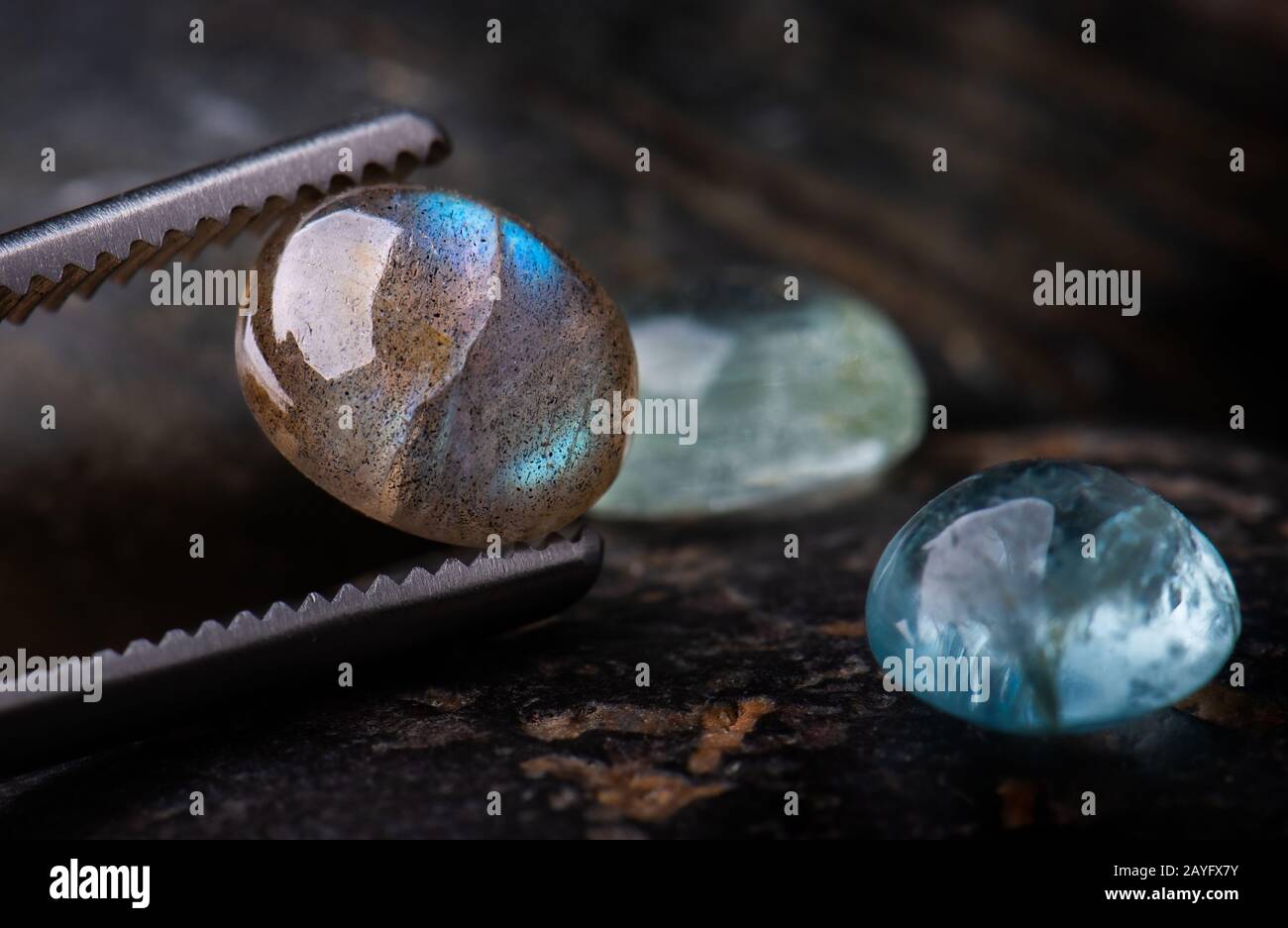 Pierres gemmes minérales de labradorite à coupe ronde avec fond de pierres sombres. Banque D'Images