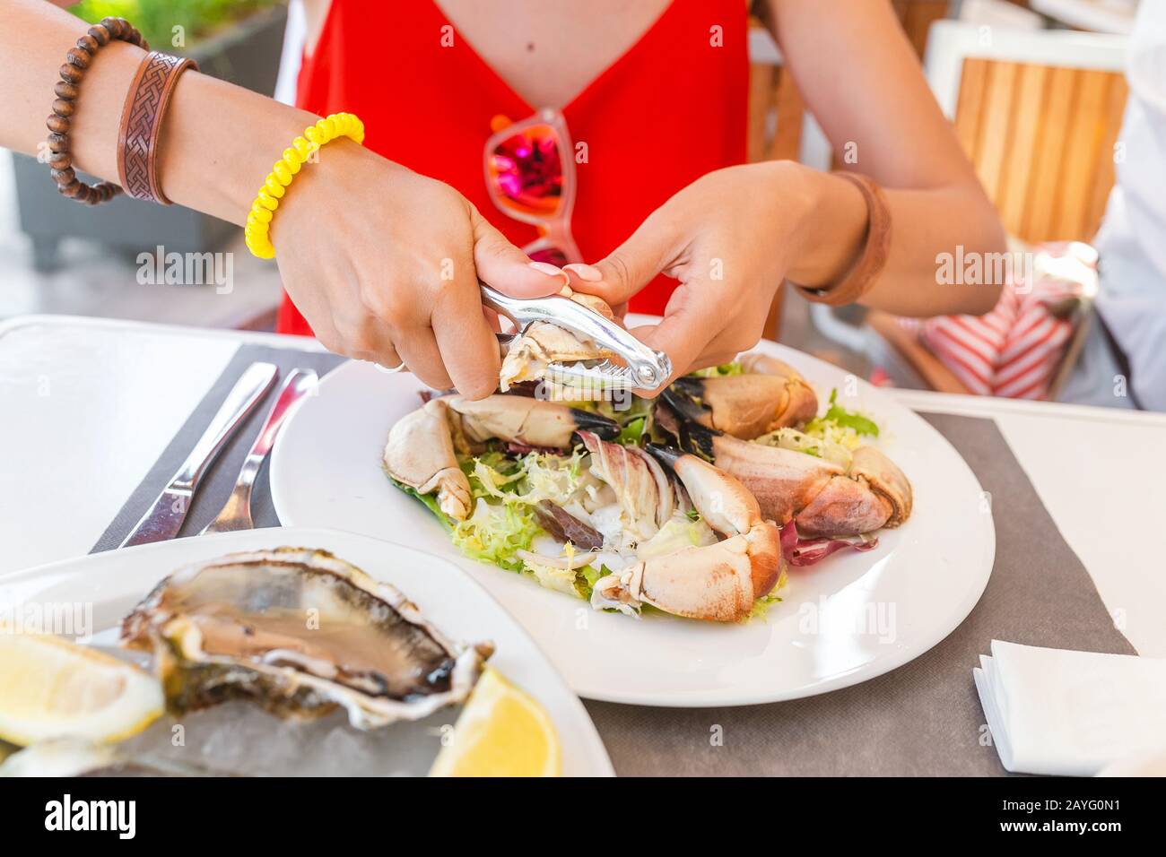 Femme mangeant la griffe de crabe à l'aide d'une pince spéciale pour atteindre la délicieuse viande blanche. Concept de cuisine méditerranéenne espagnole de fruits de mer Banque D'Images