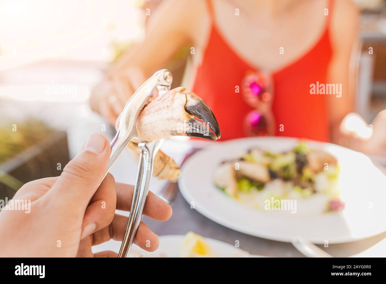 Femme mangeant la griffe de crabe à l'aide d'une pince spéciale pour atteindre la délicieuse viande blanche. Concept de cuisine méditerranéenne espagnole de fruits de mer Banque D'Images