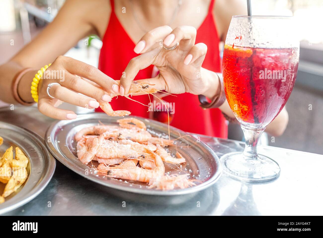 Bonne femme asiatique à chapeau manger de la cuisine espagnole locale fruits de mer grillés et crevettes Banque D'Images
