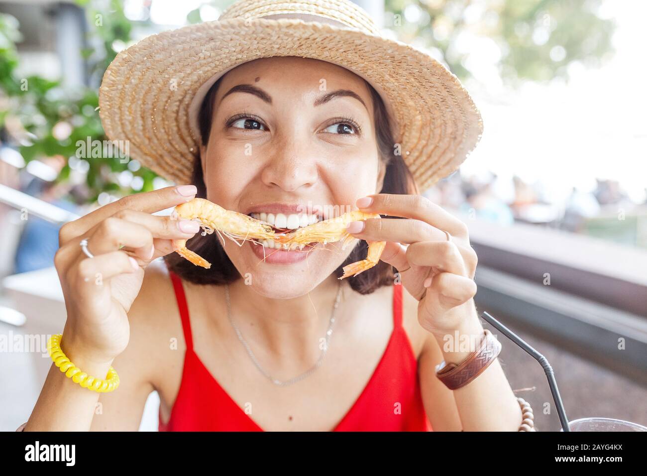 Bonne femme asiatique à chapeau manger de la cuisine espagnole locale fruits de mer grillés et crevettes Banque D'Images