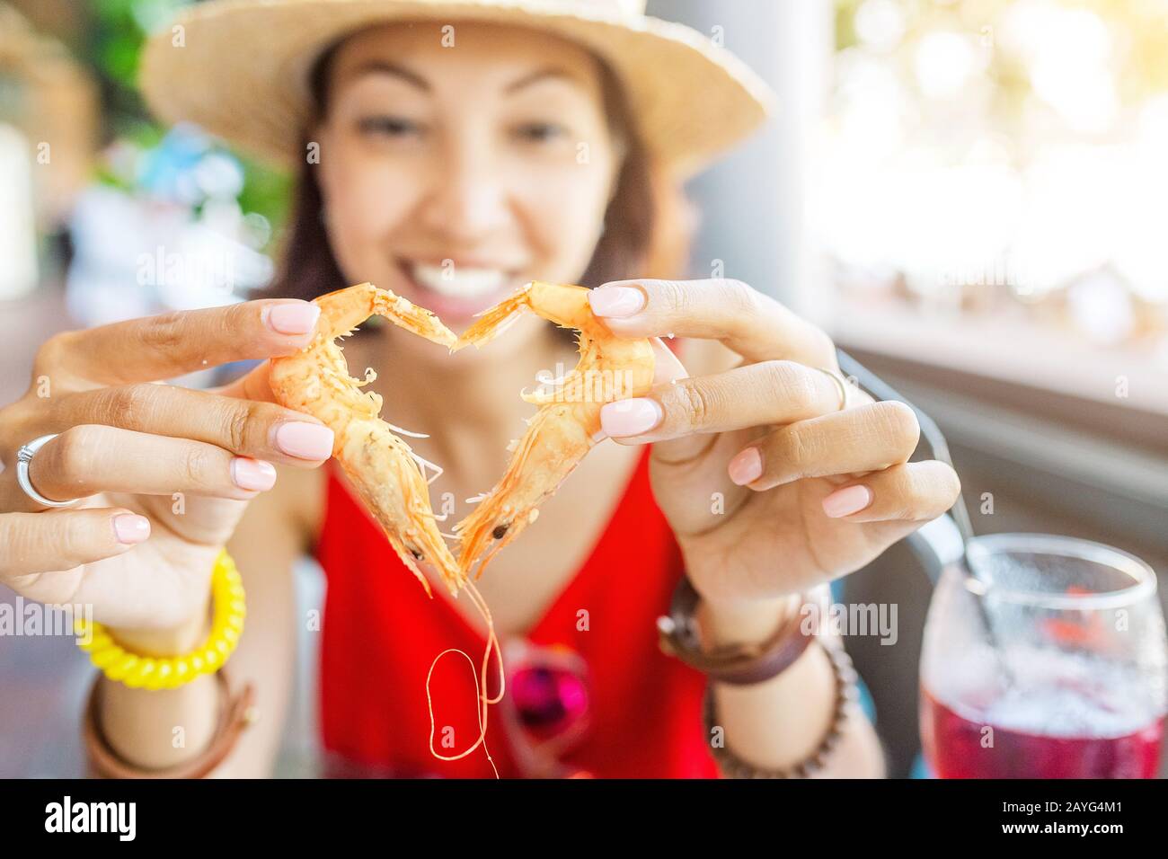 Bonne femme asiatique à chapeau manger de la cuisine espagnole locale fruits de mer grillés et crevettes Banque D'Images