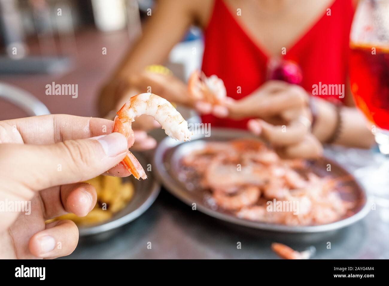 Bonne femme asiatique à chapeau manger de la cuisine espagnole locale fruits de mer grillés et crevettes Banque D'Images