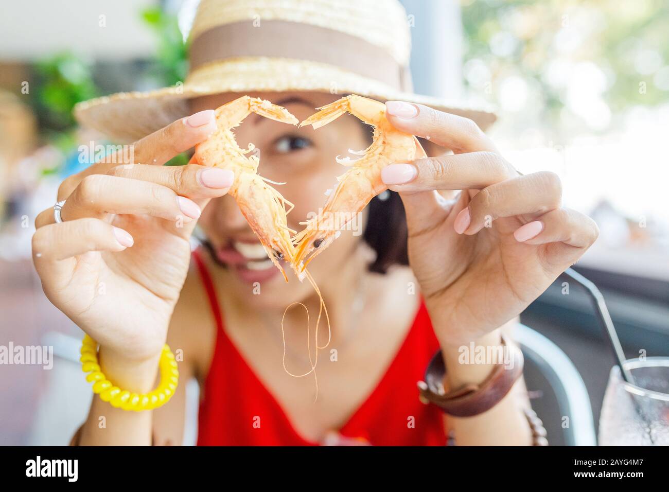 Bonne femme asiatique à chapeau manger de la cuisine espagnole locale fruits de mer grillés et crevettes Banque D'Images