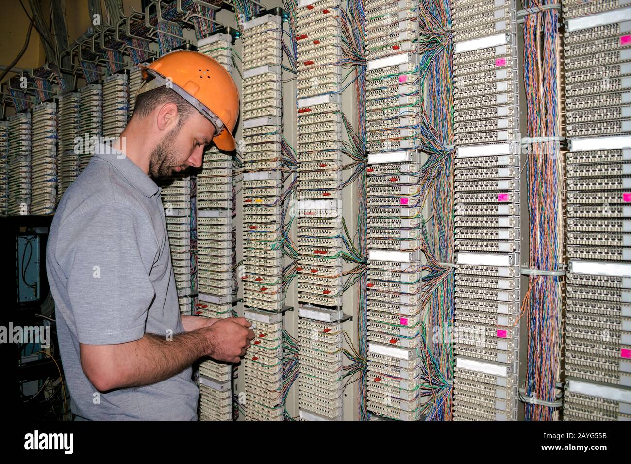 Le technicien connecte les fils au panneau de raccordement de la salle du serveur du centre de données. L'ingénieur travaille avec l'équipement d'échange téléphonique. Banque D'Images
