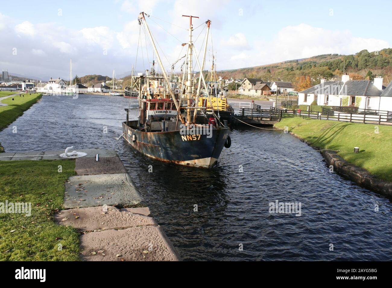 Bateau de pêche et yacht à la voile se déplaçant du verrou de mer à Corpach, au bout du canal calédonien, près de fort William, Écosse Banque D'Images