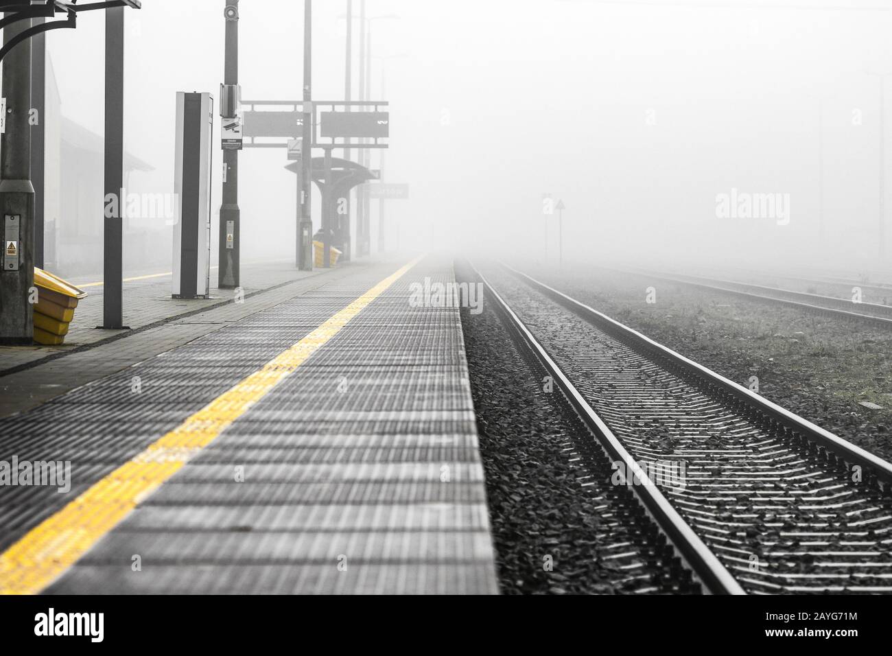 Vider la plate-forme de la gare le matin du jour de brume - image monochrome avec couleur jaune Banque D'Images