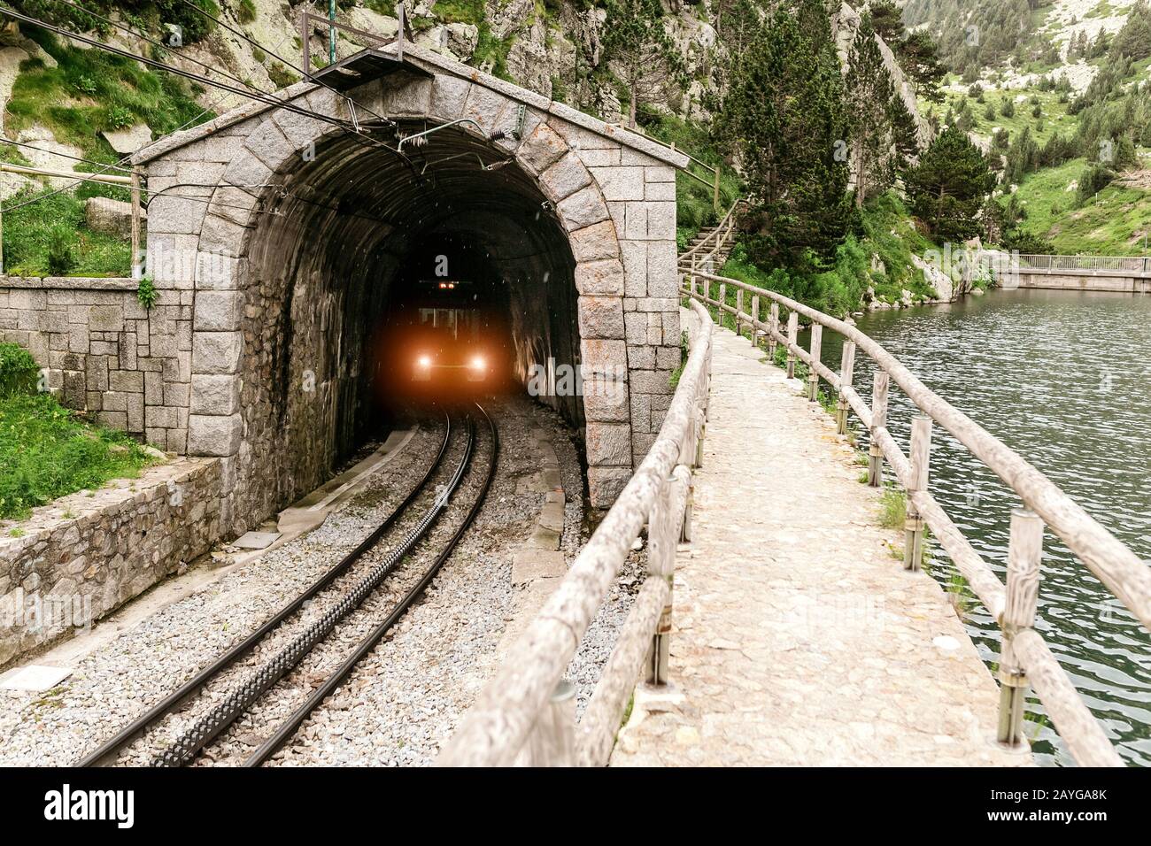 Le train quitte le tunnel dans les montagnes Banque D'Images