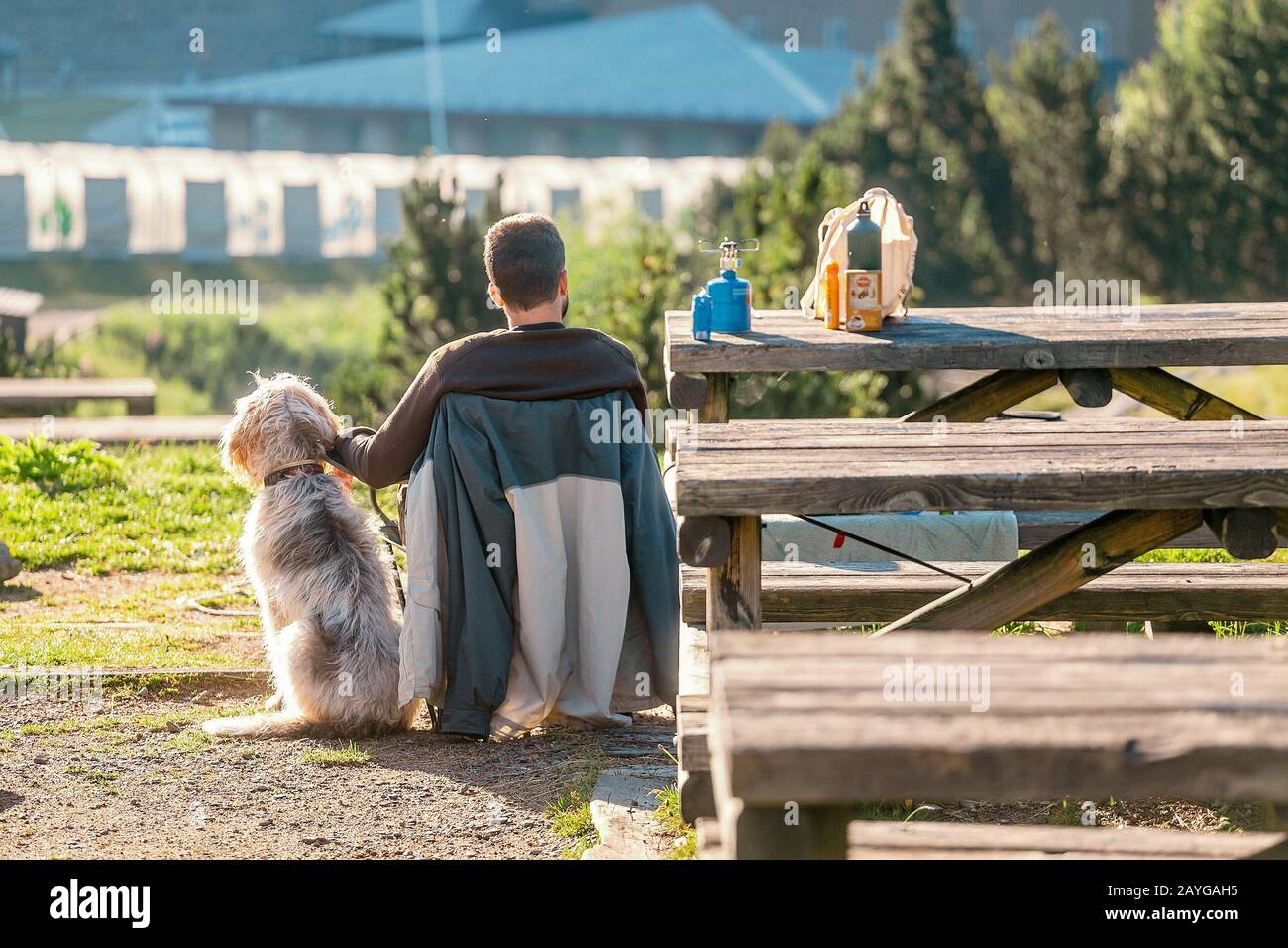 25 JUILLET 2018, NURIA, ESPAGNE: Homme assis en tente de camping avec son chien animal de compagnie Banque D'Images