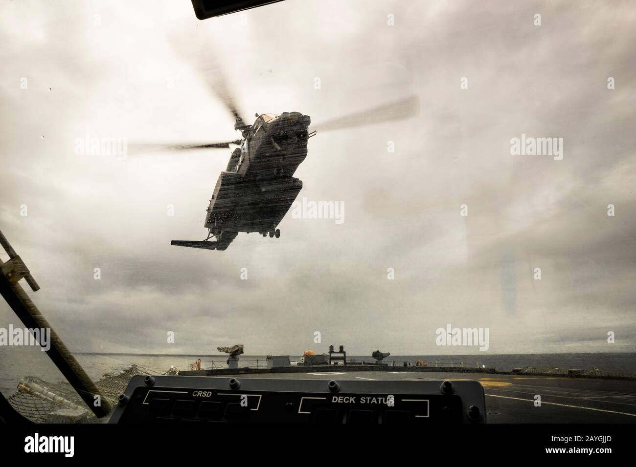 Un hélicoptère CH-148 Cyclone de la Royal Canadian Air Force atterrissant sur le pont d'un navire de guerre canadien en mer vu du poste d'agent de la sécurité d'atterrissage. Banque D'Images