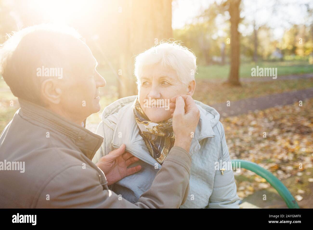 Couple senior âgé amoureux se reposant sur un banc dans le parc d'automne Banque D'Images