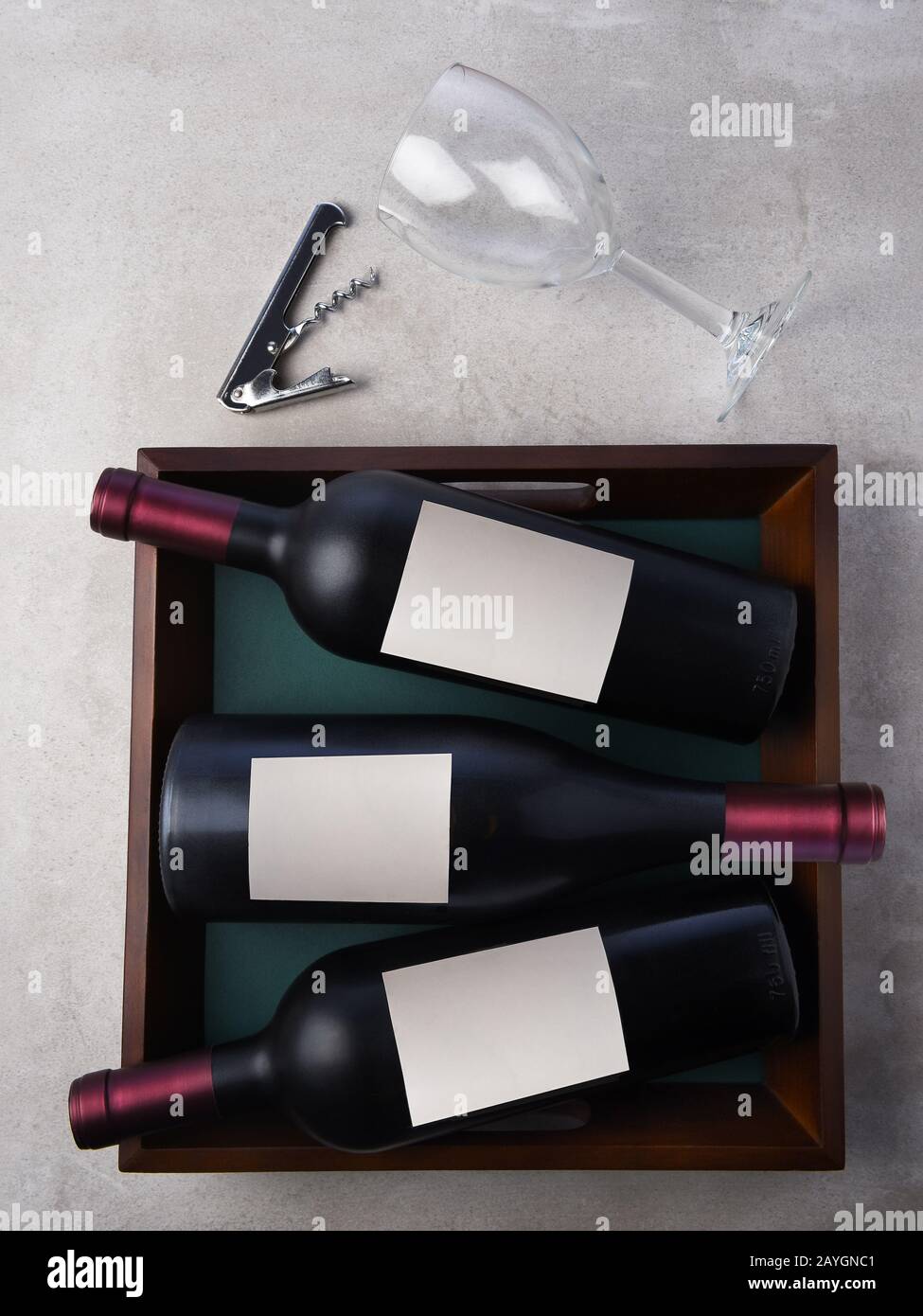Flat Lay Wine Still Life : trois bouteilles de vin placées dans un plateau avec verre à vin et corkvec. Les flacons sont dotés d'étiquettes vierges. Banque D'Images