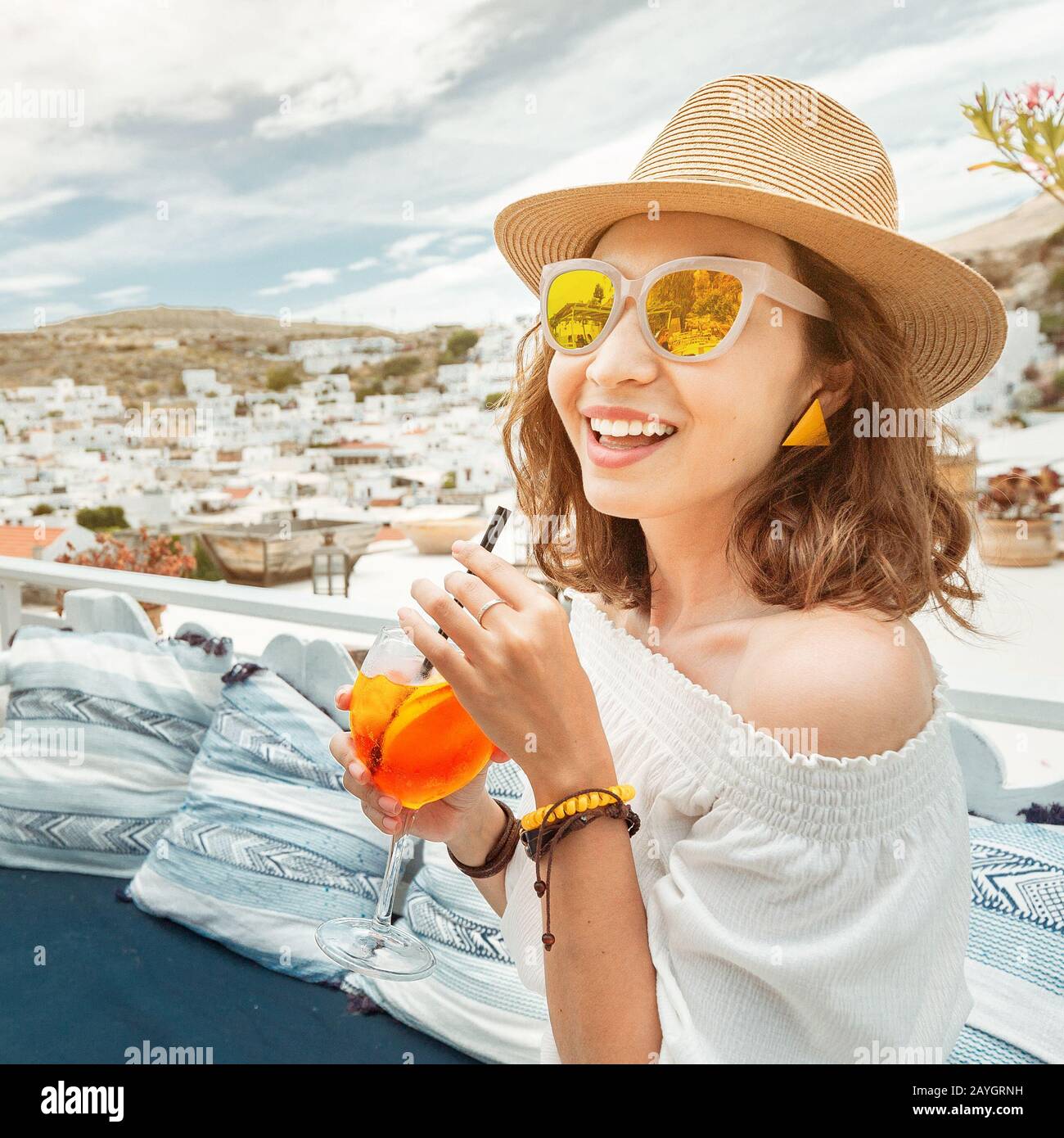 Une heureuse femme asiatique qui profite d'un cocktail apérol spitz dans un café grec. Concept de boissons et de rafraîchissements Banque D'Images