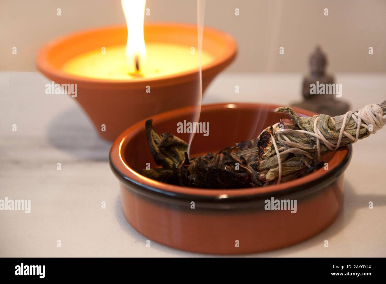 Cérémonie Sage Smudge Blanc feu de bâton avec une flamme de bougie brûlant en arrière-plan Banque D'Images