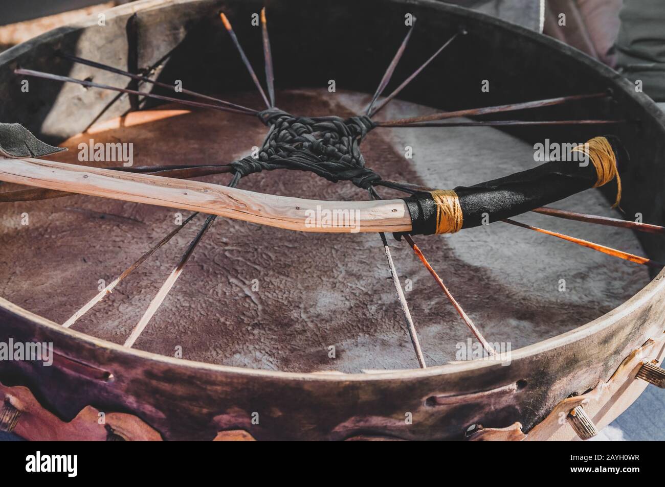 Détail gros plan d'un tambour de cuir rituel de méditation spirituelle chamanique avec une branche naturelle en bois sauvage fait à la main pour une cérémonie de chamanisme Banque D'Images