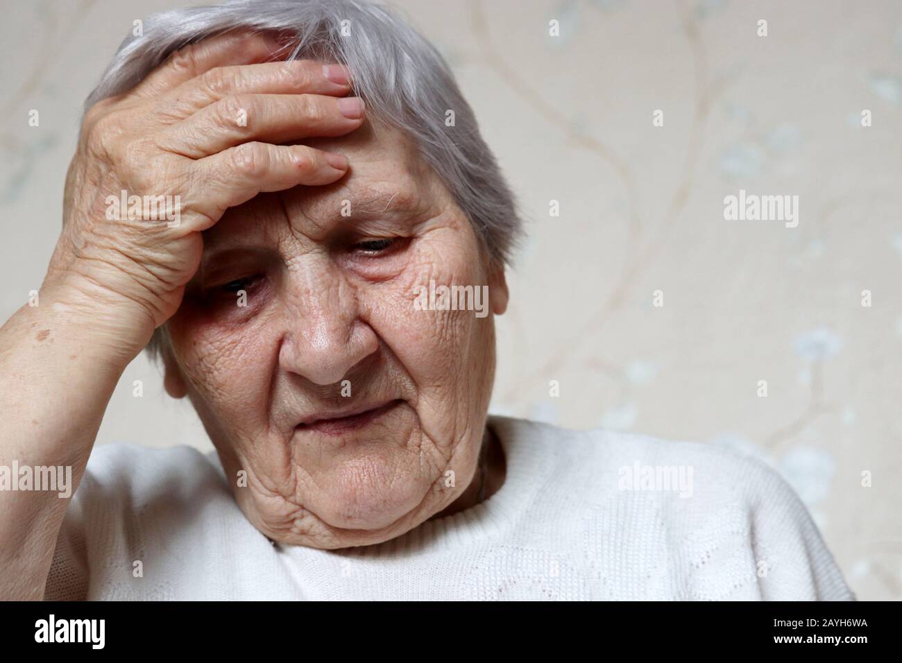 Une femme âgée a mis la main sur le front. Femme avec cheveux gris, concept de maux de tête, pression et vieillesse Banque D'Images