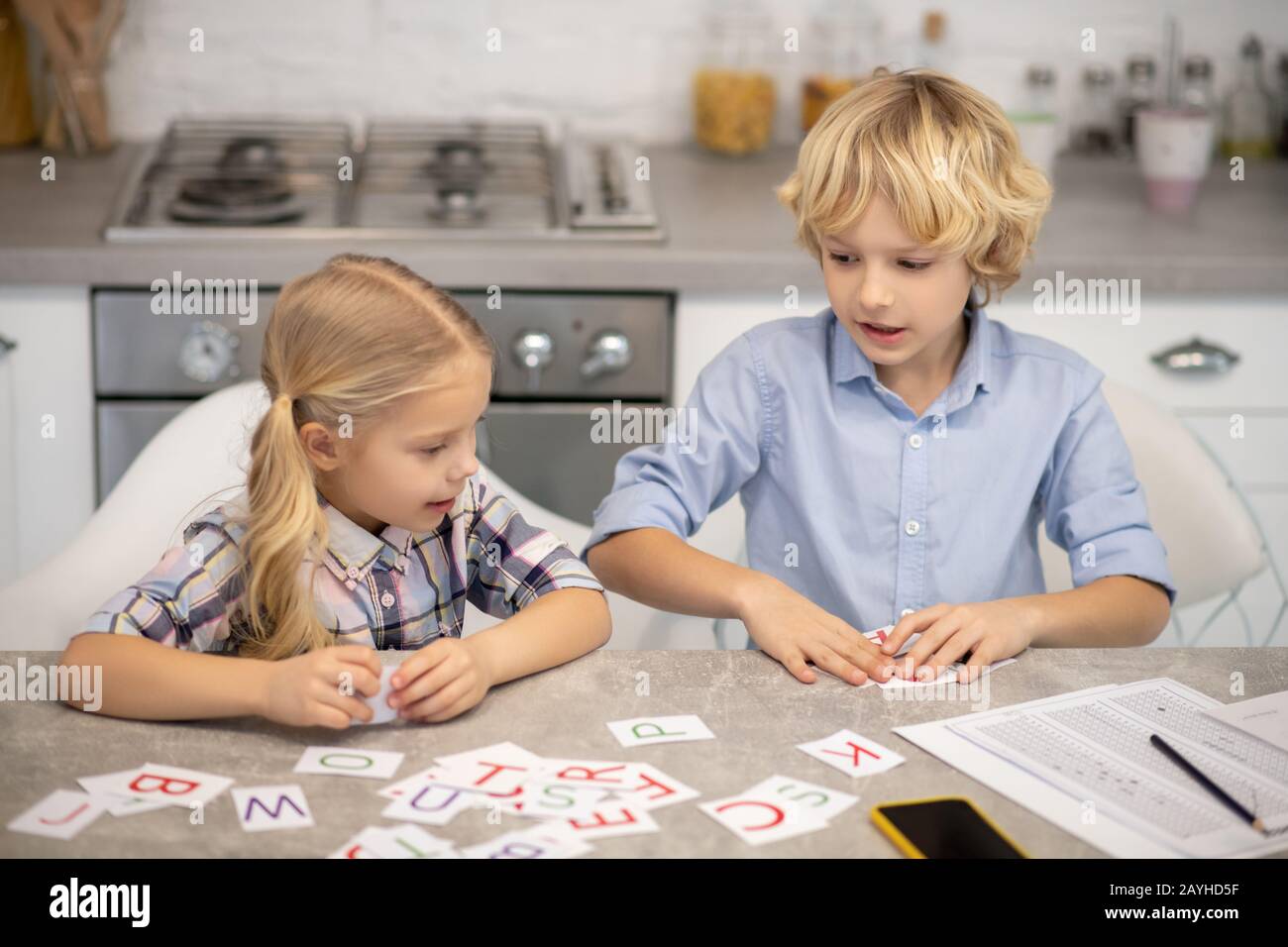 Deux enfants blonds qui font des mots et se sentent impliqués Banque D'Images