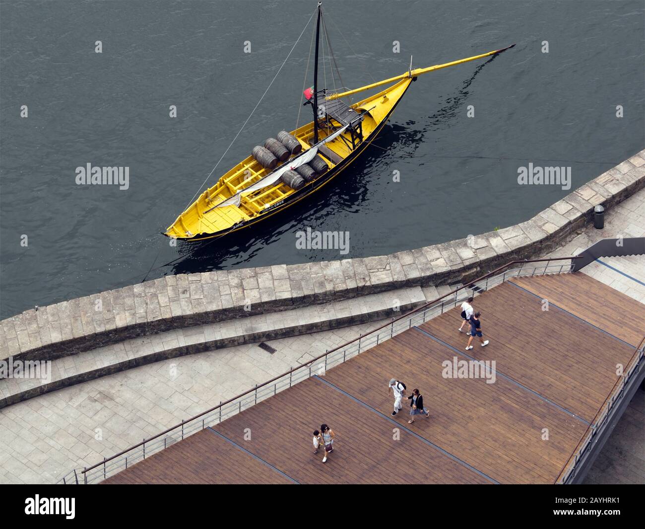 Les touristes marchant le long du fleuve Douro avec une barge de port jaune vif, Porto, Portugal Banque D'Images