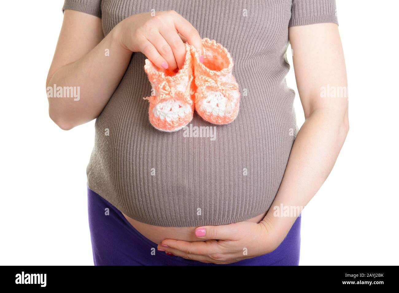 Femme enceinte tenant une belle chaussures de bébé en laine isolée sur blanc Banque D'Images Femme enceinte tenant une belle chaussures de bébé en laine isolée sur blanc Banque D'Images