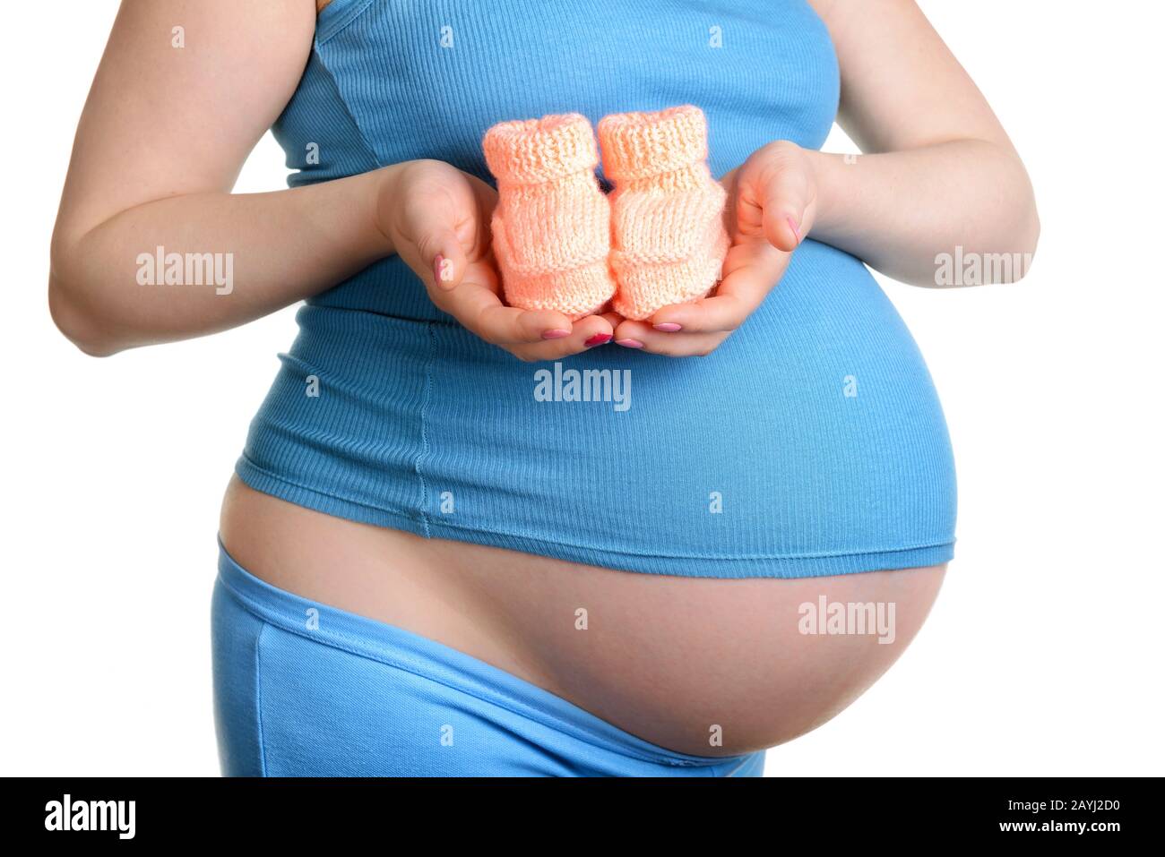 Femme enceinte tenant une belle chaussures de bébé en laine isolée sur blanc Banque D'Images Femme enceinte tenant une belle chaussures de bébé en laine isolée sur blanc Banque D'Images