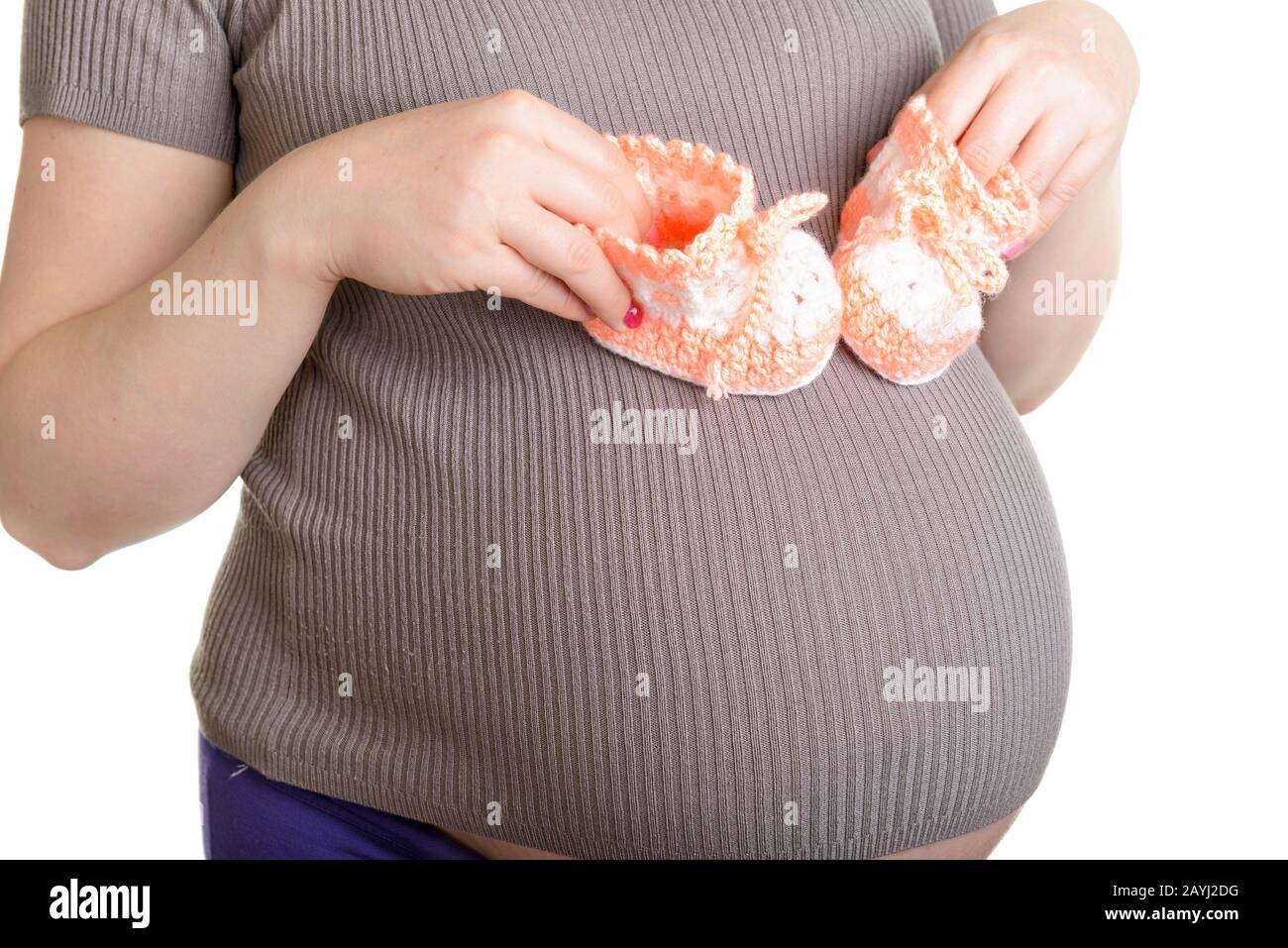 Femme enceinte tenant une belle chaussures de bébé en laine isolée sur blanc Banque D'Images Femme enceinte tenant une belle chaussures de bébé en laine isolée sur blanc Banque D'Images
