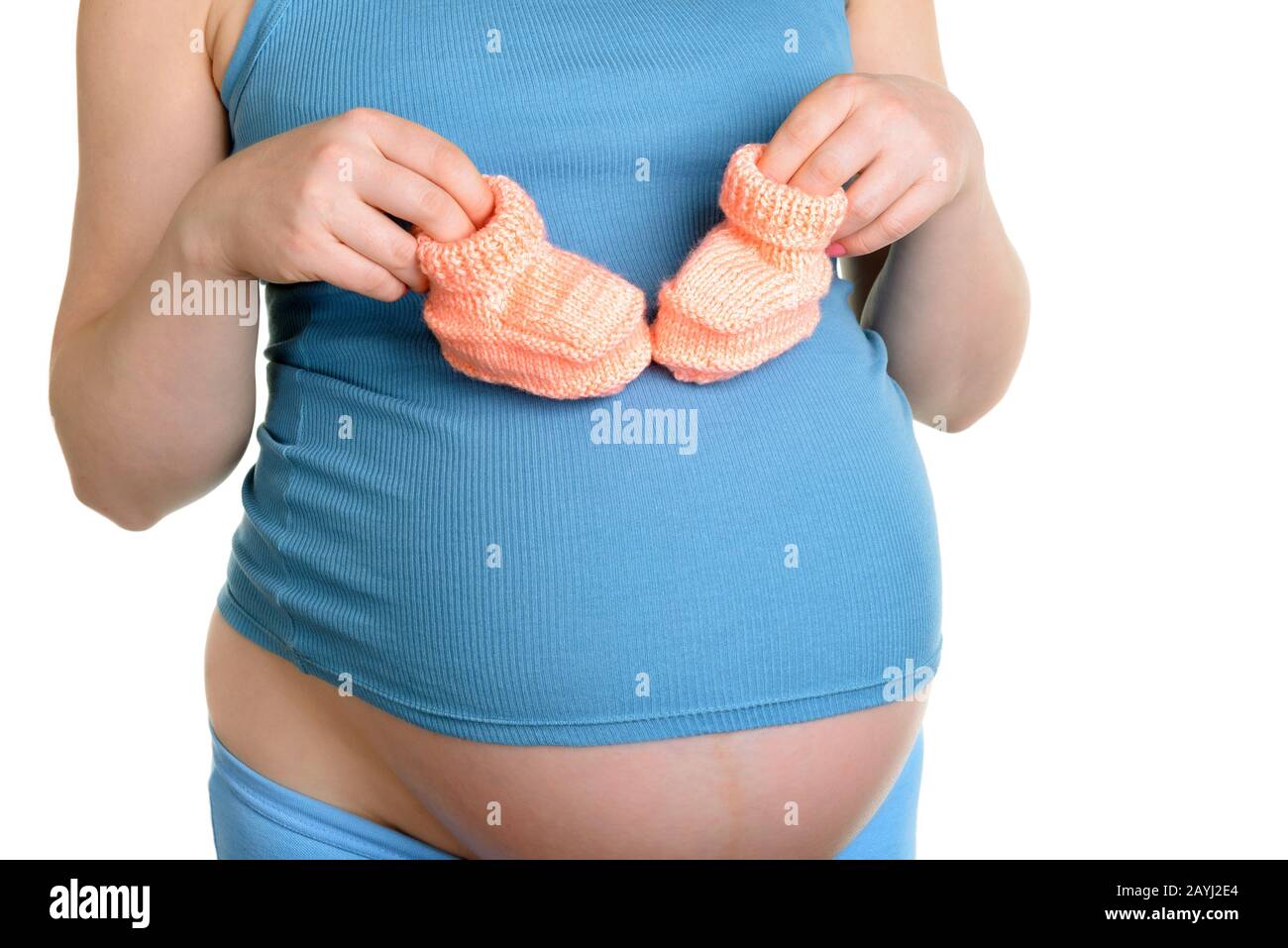 Femme enceinte tenant une belle chaussures de bébé en laine isolée sur blanc Banque D'Images Femme enceinte tenant une belle chaussures de bébé en laine isolée sur blanc Banque D'Images