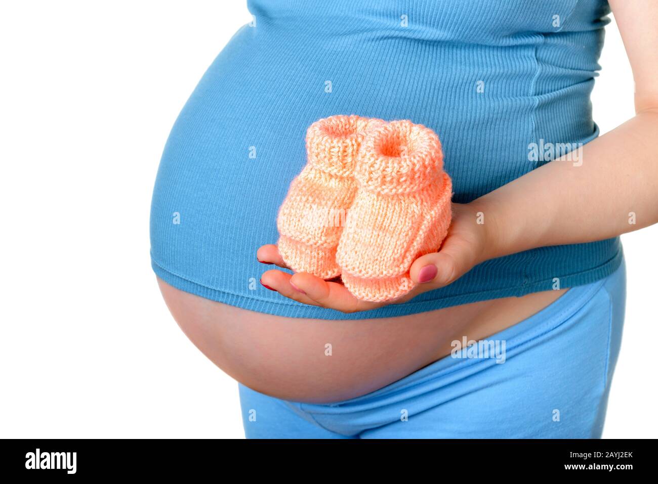 Femme enceinte tenant une belle chaussures de bébé en laine isolée sur blanc Banque D'Images Femme enceinte tenant une belle chaussures de bébé en laine isolée sur blanc Banque D'Images