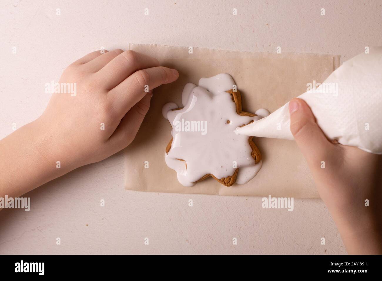 Un garçon de 10 ans vire les cookies avec un sac culinaire. Fait Main. La créativité des enfants Banque D'Images