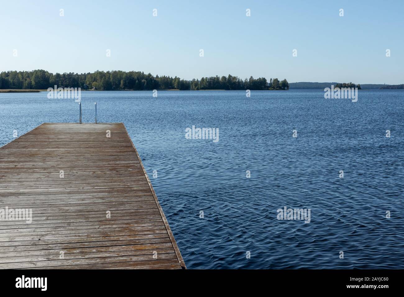 Quai de baignade en bois avec échelle en métal sur lac bleu calme journée ensoleillée sur la nature Finlande station naturelle idyllique Banque D'Images