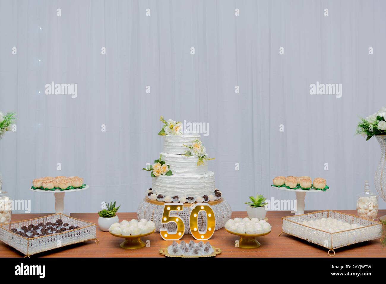 Un Beau Gateau Pour Le 50eme Anniversaire Decore Fete D Anniversaire De Table Avec Un Gateau Blanc A Deux Etages Decore De Roses Jaunes Et De Son Vert Photo Stock Alamy