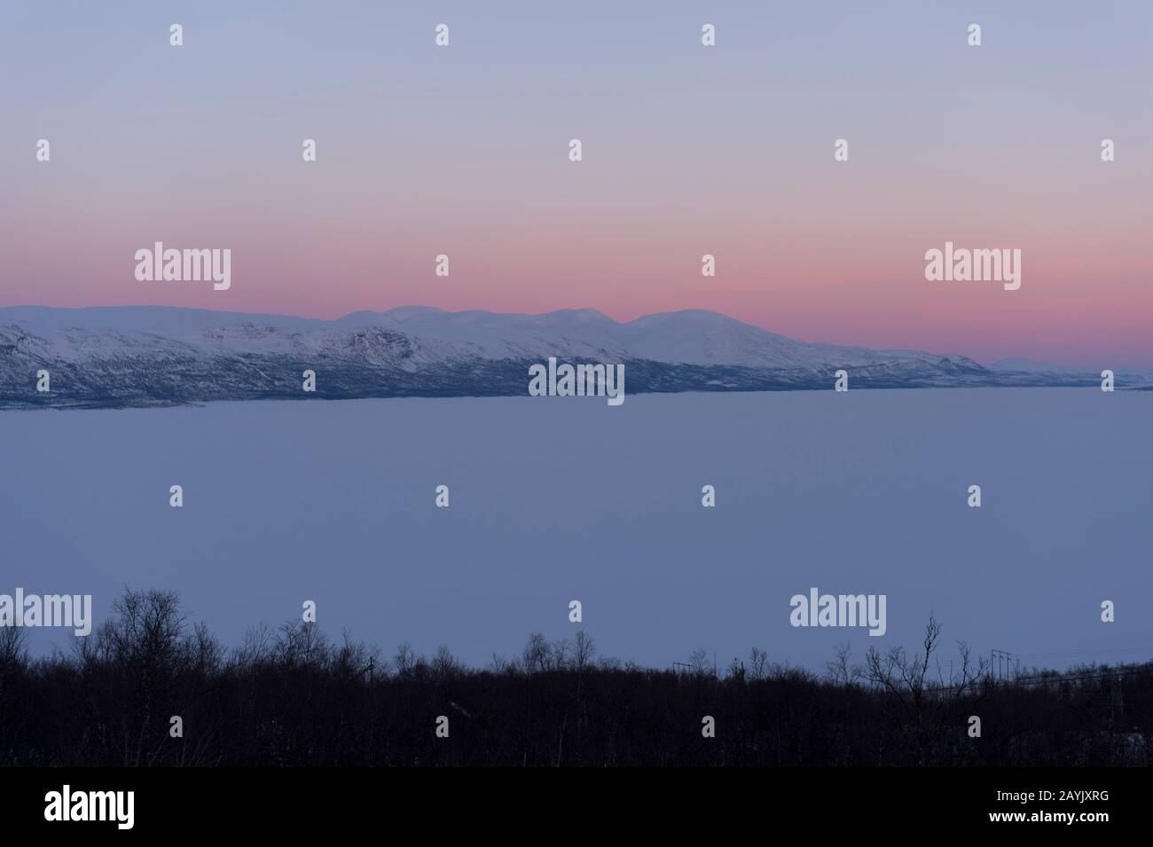 Vue depuis la zone de l'hôtel Fjallet du lac Tornetrask, gelé et enneigé, en Laponie suédoise, dans le nord de la Suède. Banque D'Images