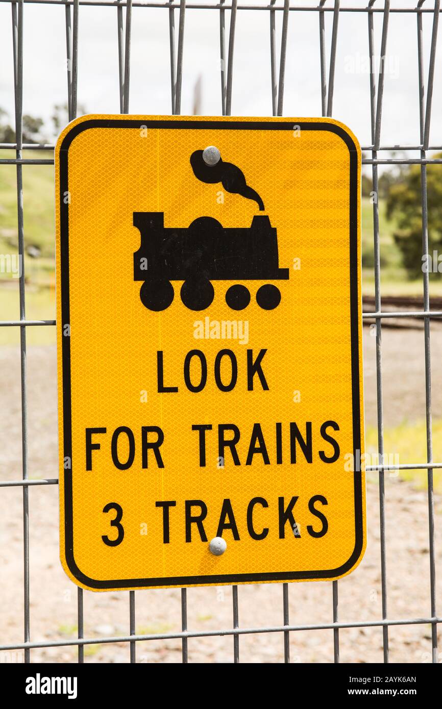 Un panneau réfléchissant avertissant les piétons De Rechercher Des Trains avant de traverser 3 voies ferroviaires Banque D'Images