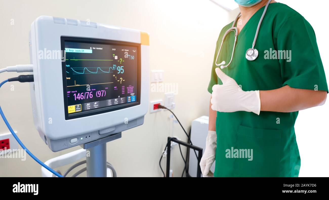 Santé et concept médical. Médecin de médecine avec stéthoscope et gants à la main et moniteur EKG avec électrocardiogramme de pouls à l'hôpital. Banque D'Images