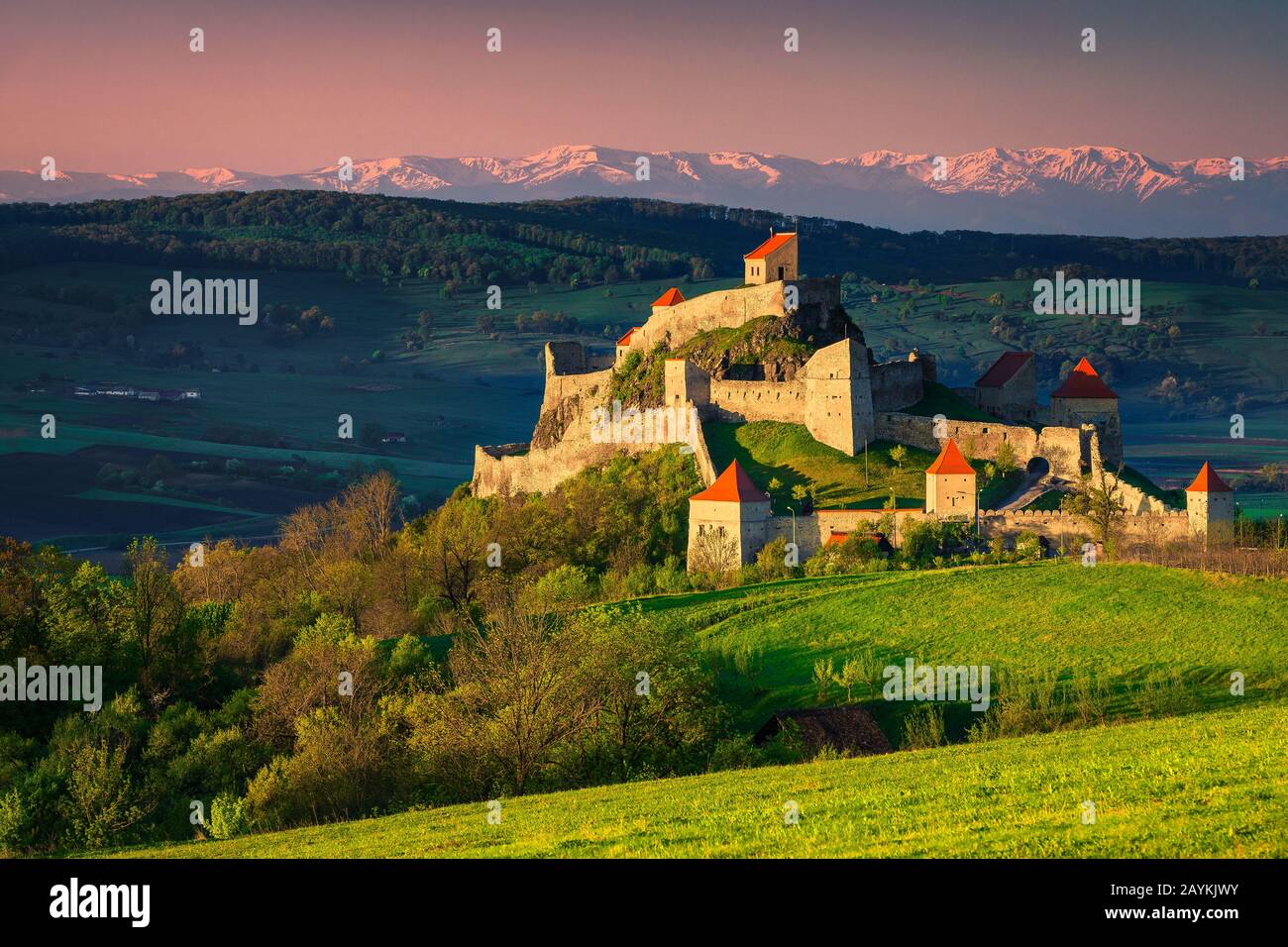 Majestueuse forteresse de Rupea sur la colline, belle fortification et hautes montagnes enneigées en arrière-plan, Brasov, Transylvanie, Roumanie, Europe Banque D'Images