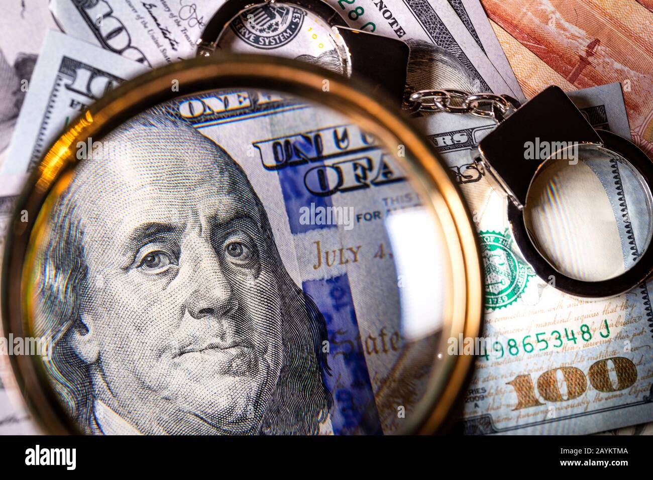 Dollars américains sous une loupe et des menottes Banque D'Images