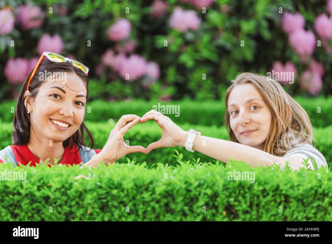 Joyeux amis qui s'amusent dans un parc fleuri au printemps Banque D'Images